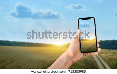 Tourist taking a photo of nature using a smartphone, point of view shot