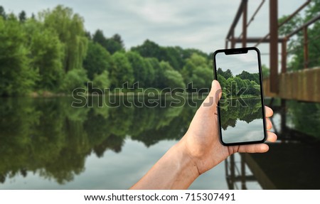 Tourist taking a photo of nature using a smartphone, point of view shot