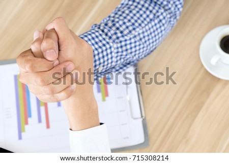 top-view of two asian business man arm-wrestle during discussing document about finance on table at meeting time, fight business concept