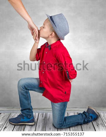 Little boy kisses the hand of the mother.