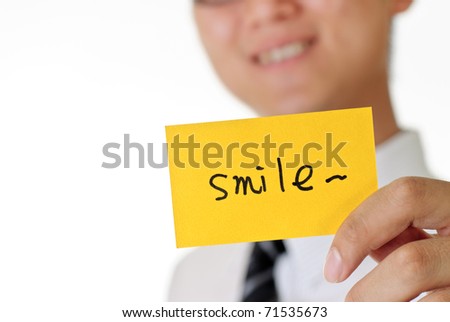 Smile, words on yellow card holding by young man.