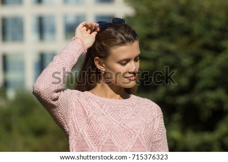 Young cute woman adjusts sunglasses