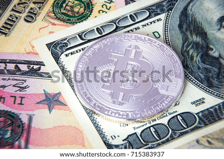 Silver bitcoin coin on US dollars; Financial concept; Closeup view