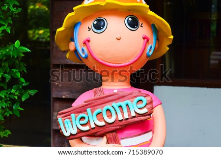 welcome with smile doll in the front of coffee shop
