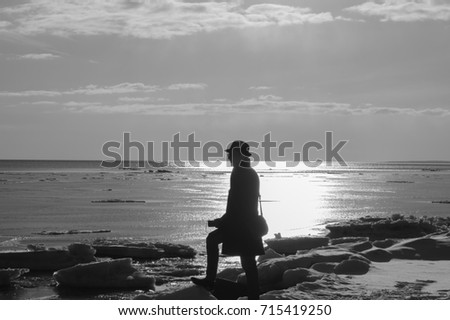 Lonely man walking on a beach black and white