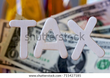 Tax sign with a background of American dollars.
