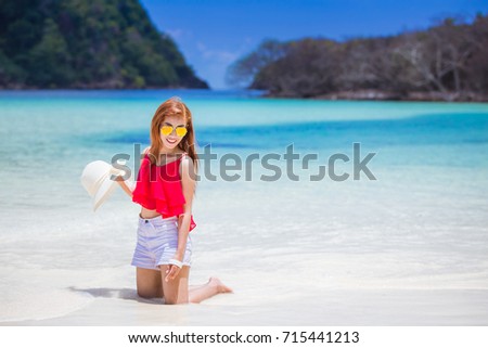 Young fashion woman relax on the beach. Happy island lifestyle. White sand, blue