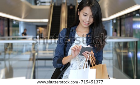 Woman go shopping and carry shopping bags and cellphone Royalty-Free Stock Photo #715451377
