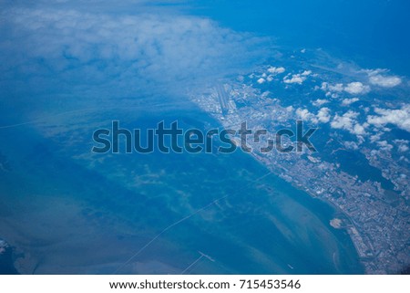Clouds and sky at Penang Island, Malaysia as seen through window of an aircraft.