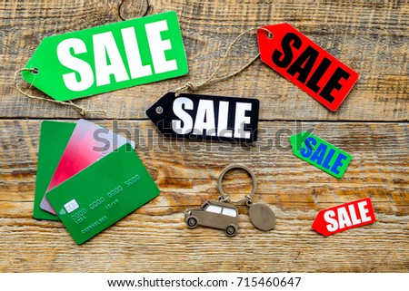 Colored sale labels, car keys and bank cards on wooden background top view copyspace