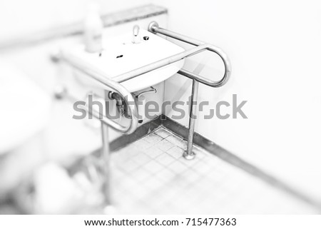 The assistance bars for disabled and elderly people in public restroom in Japan. 
This image was blurred or selective focus. Black and white picture.