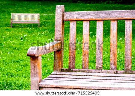 wooden parkbench at a park Royalty-Free Stock Photo #715525405