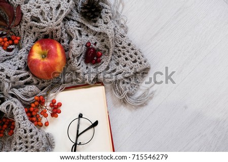 Cozy winter still life: cup of hot coffee and opened book. Cup of tea with open book and bunch of red rowan on wooden background, vintage picture style. Autumn, fall leaves, Flat lay, top view