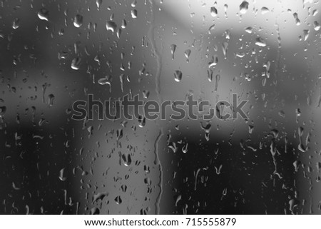 Water drops on house window with blur background in black and white. abstract wallpaper and texture.