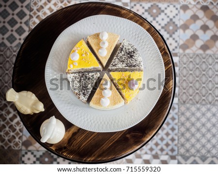 Various pieces of colorful cakes: poppy seed cake, lemon and creamy with meringue. view from above, tile floor on a background