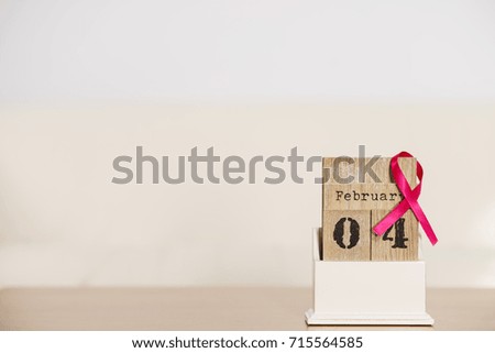 Old fashioned calendar with 4 february world breast cancer day, date with pink awareness ribbon. Healthcare and medicine concept.