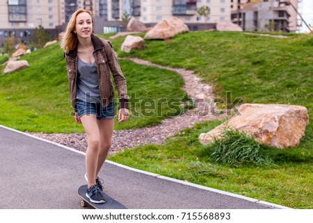 skater girl on the street on a skateboard moving 
