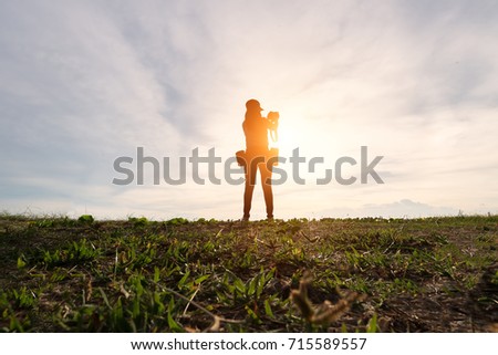 silhouette of photographer taking picture of landscape during sunset. Lifestyle Concept

