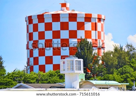 A red and white checkered water tower in
