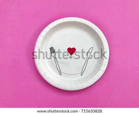 Closeup A white paper plate set on pastel pink background. The concept of party accessories, food display. Top view with Copy space. Selective focus.