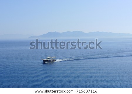 Panorama of calm sea and mountainous horizon with small boat