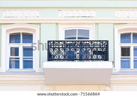 Windows and  balcony with  grate on  wall of  ancient building, Russia.