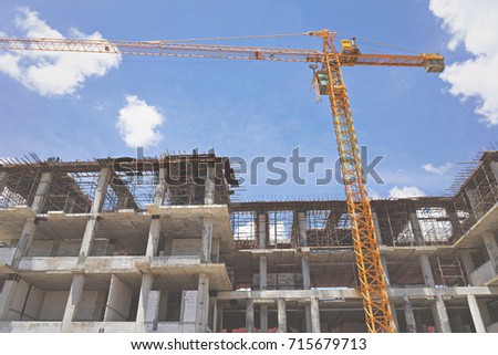 Construction site with crane and building blue sky background.
