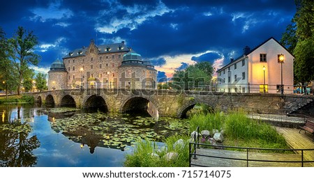 Panoramic HDR image of Orebro Castle and bridge reflecting in water of Svartan river at dusk, Sweden Royalty-Free Stock Photo #715714075