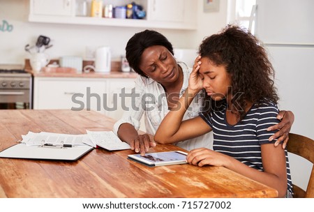 Mother Helps Stressed Teenage Daughter With Homework Royalty-Free Stock Photo #715727002