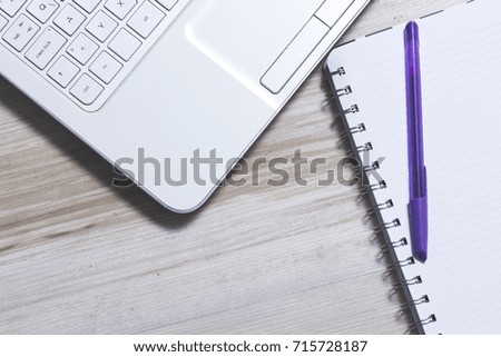 Business concept, laptop and blue diary on wooden background