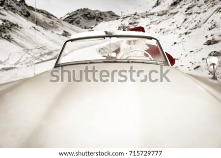 Santa claus in white cabriolet on winter road in Alps 