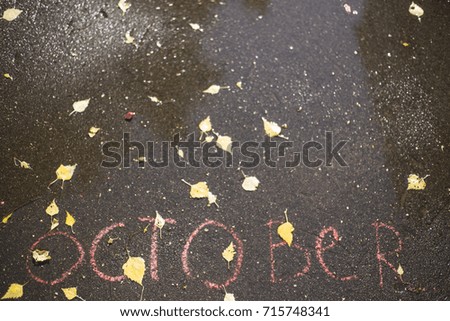 Autumn background: written on the asphalt word October
