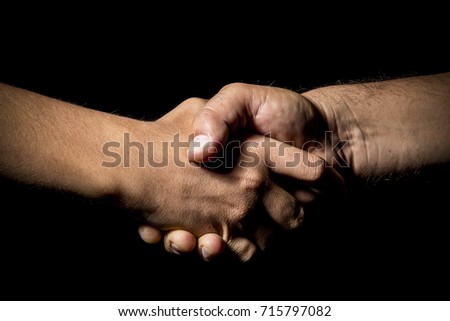 hands of men making deal salute on black background