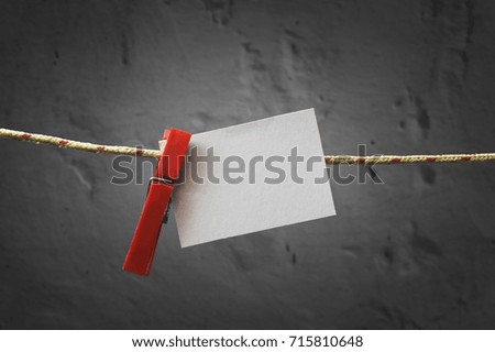 Paper note attach to rope with clothes pins on dark background