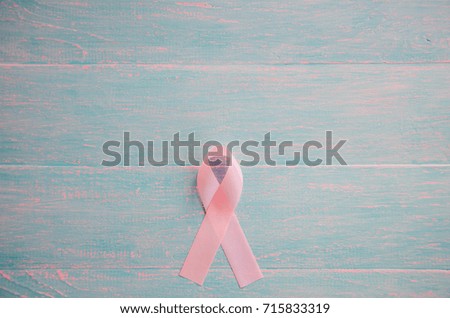 Pink ribbon on a wooden background from below. breast cancer