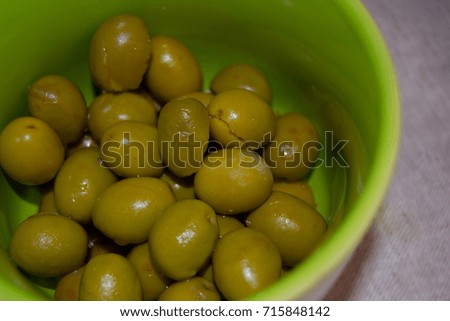 Green crushed olives in a green bowl. Closeup. Snack, starter or appetizer.