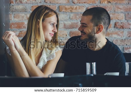Young man and woman on a date flirting. Couple sitting in the coffee shop Royalty-Free Stock Photo #715859509