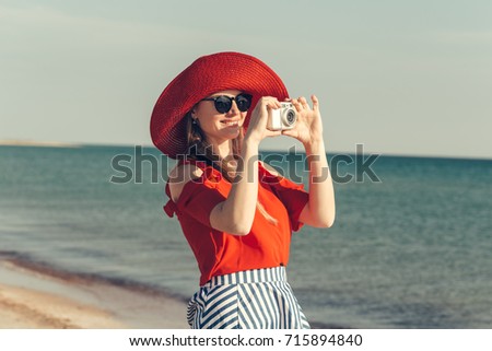 Summer beach woman holding camera taking picture