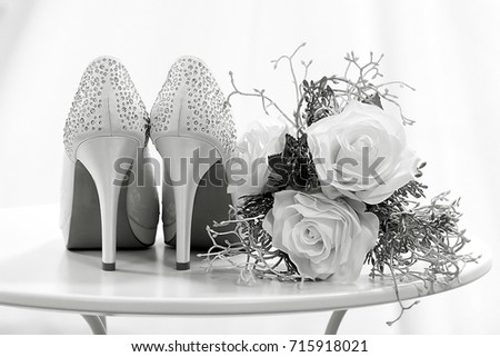 Wedding shoes and flowers on a table black and white