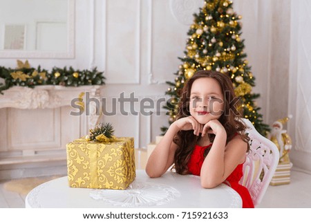Festive concept happy little smiling girl with christmas gift box xmas decorative tree background