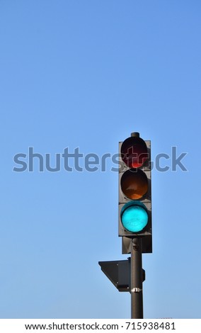 generic traffic signal against a pale blue sky. large copy space