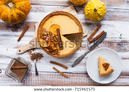 Pumpkin cheesecake,pumpkins,cinnamon on the wooden table. Top view.