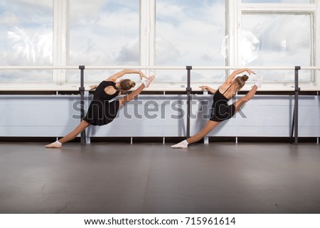 Two girls ballerinas perform exercises in the classroom for choreography classes