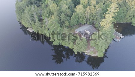 Aerial Cabin in the Woods and swimming dock on a beautiful lake with the early morning sun