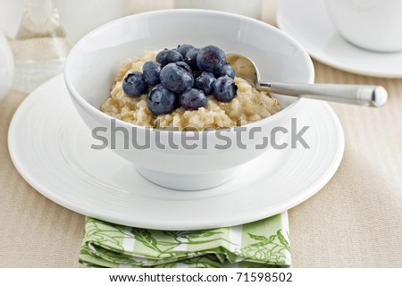 Large flake whole oatmeal with blueberries and brown sugar on white china makes a healthy breakfast Royalty-Free Stock Photo #71598502
