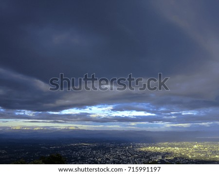 Dark blue sky clouds and sunlight through the land if city