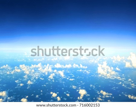 The image of the clouds and sky as seen through window of an aircraft.