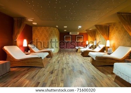 SPA restroom interior and row of wooden beds with white towels