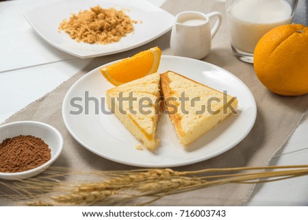 Butter bread with orange on white table.