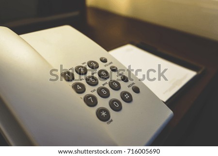 Telephone and Notebook on Table
